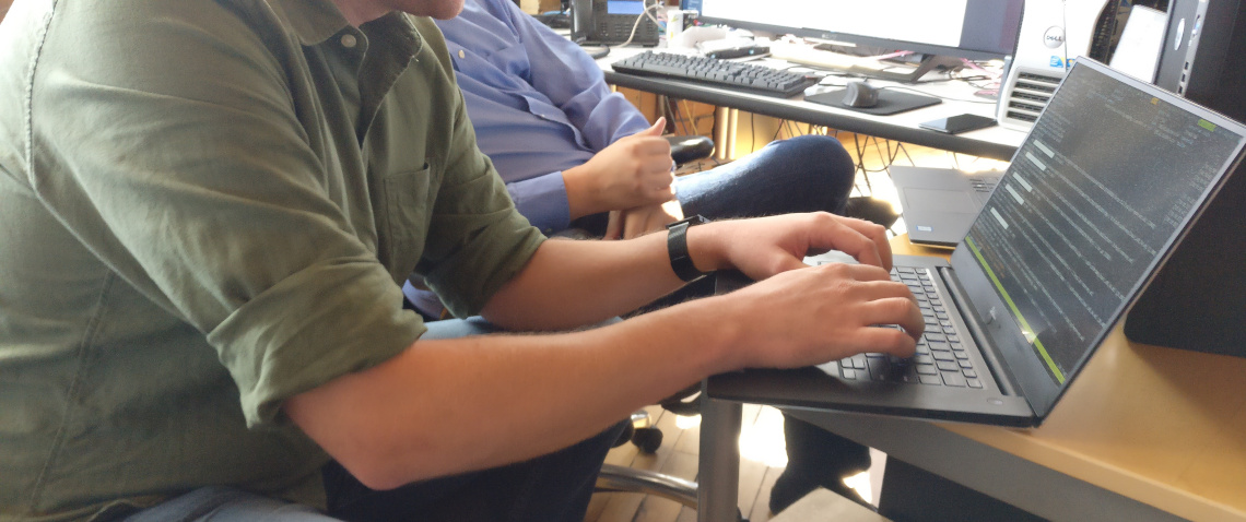 A software developer typing at a laptop.