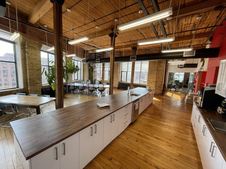 Uncharted's newly renovated kitchen with a large island and several tables for coworking and eating.