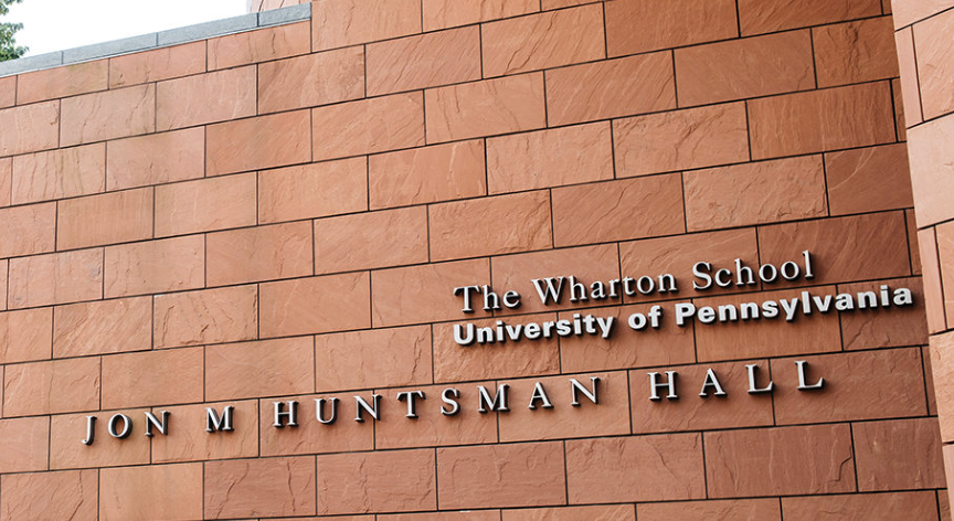 Sign for The Wharton School University of Pennsylvania Jon M Huntsman Hall on a brick wall